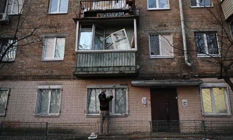 Ein Einwohner in Kiew repariert ein zerbrochenes Fenster in einem Wohnhaus, das während der russischen Streiks beschädigt wurde