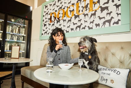 Eine Frau und ein Hund sitzen an einem Tisch