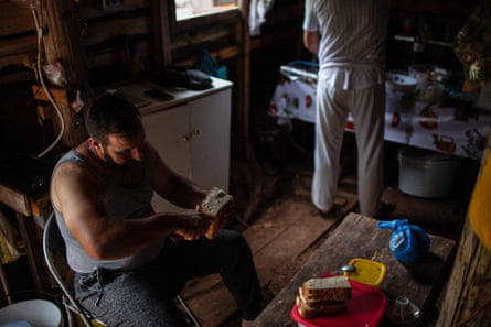 Kostas schneidet Brot für das Mittagessen der Familie in ihrer provisorischen Sommerscheune