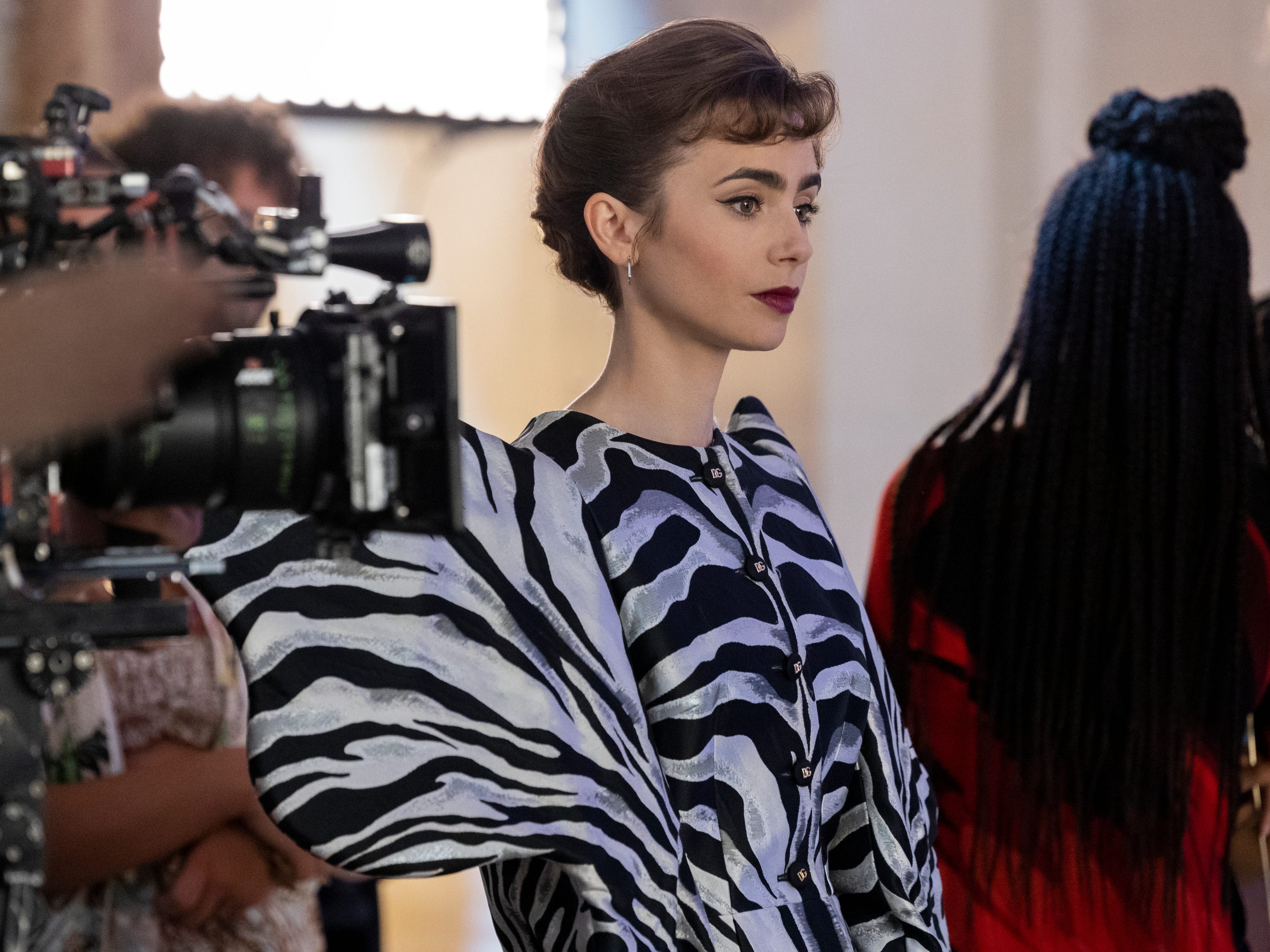 Lily Collins trägt die Jacke mit Zebramuster bei den Dreharbeiten zu „Emily in Paris“.