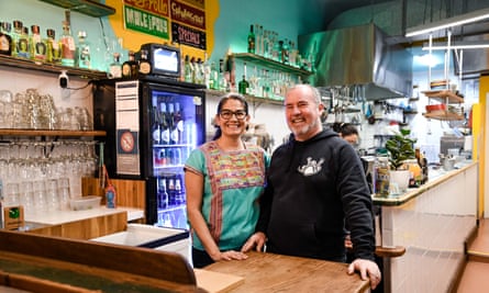 Daniella Guevara Munoz und Korjent van Dijk stehen in ihrem Restaurant hinter der Bar