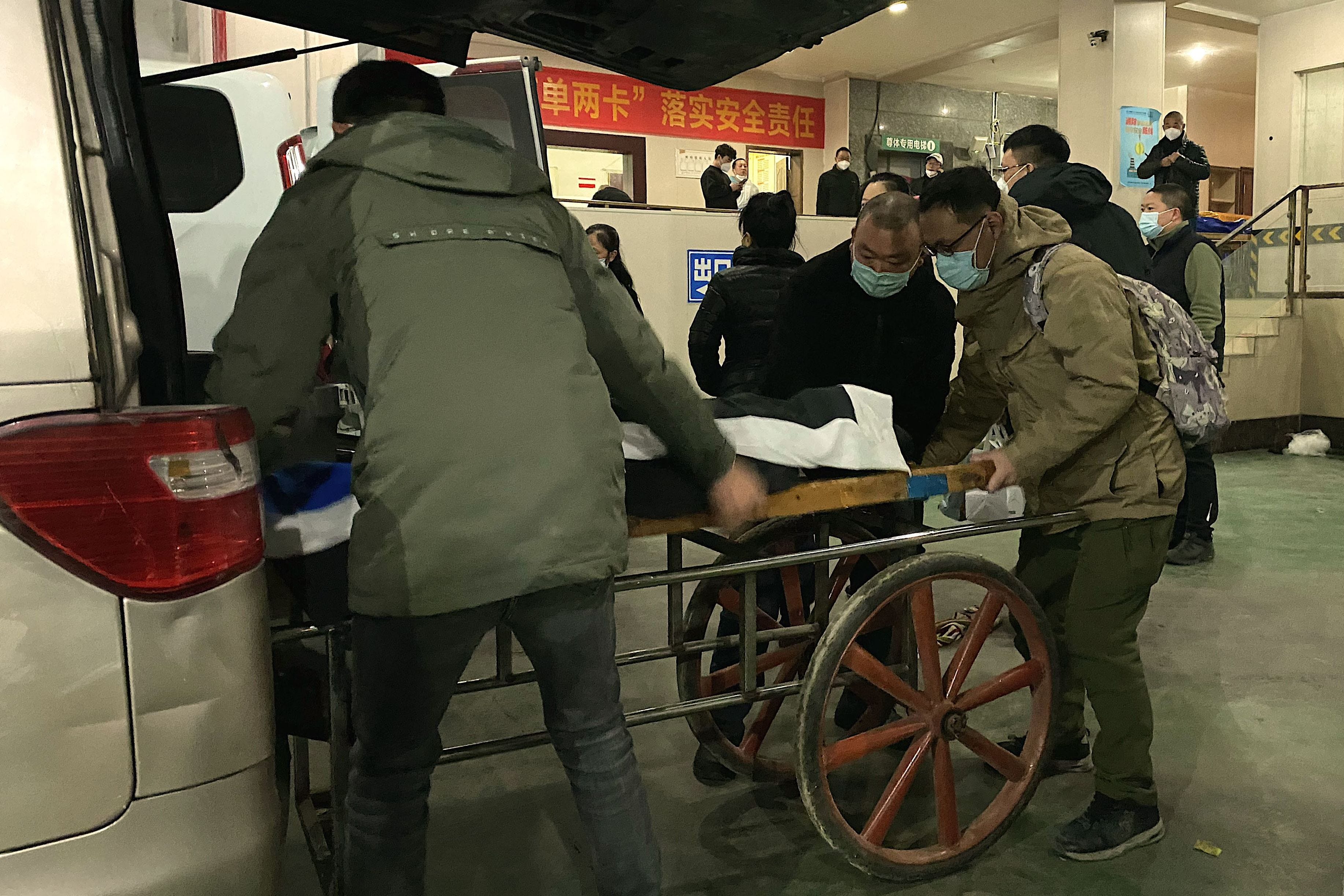 Ein Bestattungsarbeiter legte am 22. Dezember 2022 eine Leiche auf einen Karren, um sie in einem Krematorium in der südwestchinesischen Stadt Chongqing einzuäschern.