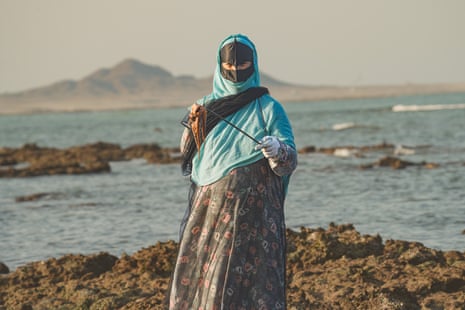 Shefeya al-Farsi ist seit 40 Jahren Teil der Rahas- oder Meeresschneckenfischerei auf der Insel Masirah.  Hier hält sie einen Tintenfisch hoch, den sie vom Ufer aufgespießt hat.