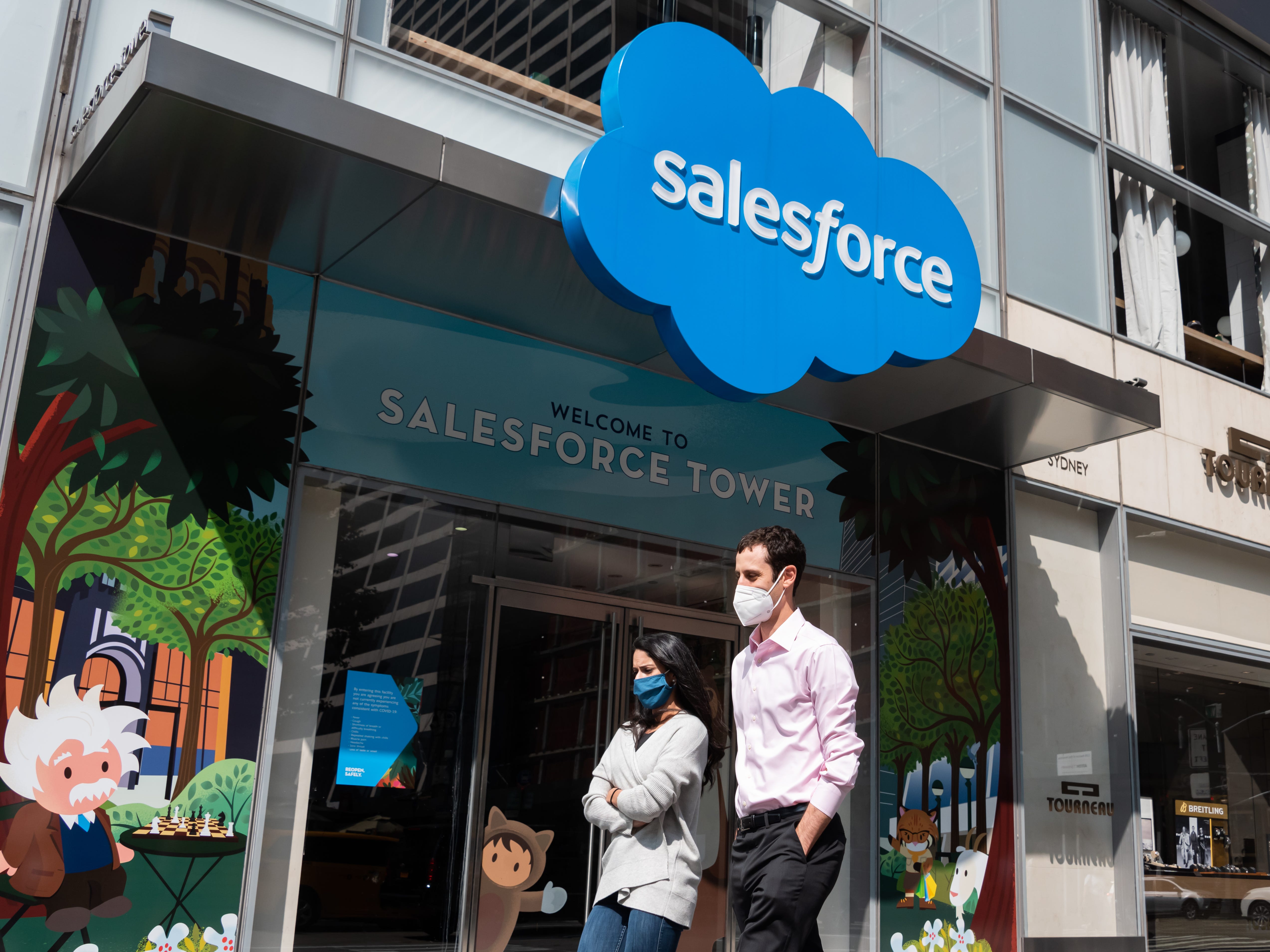 Menschen tragen vor dem Salesforce Tower Schutzmasken.