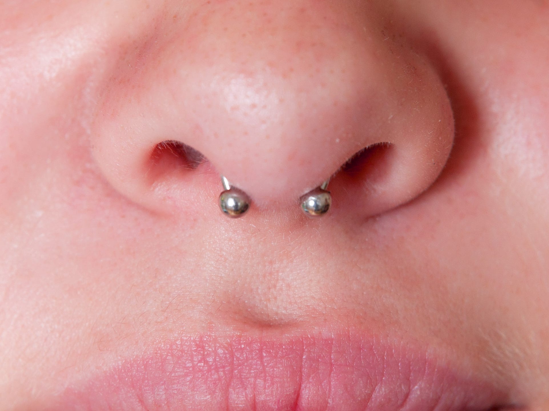 silbernes Septum-Piercing in jemandes Nase