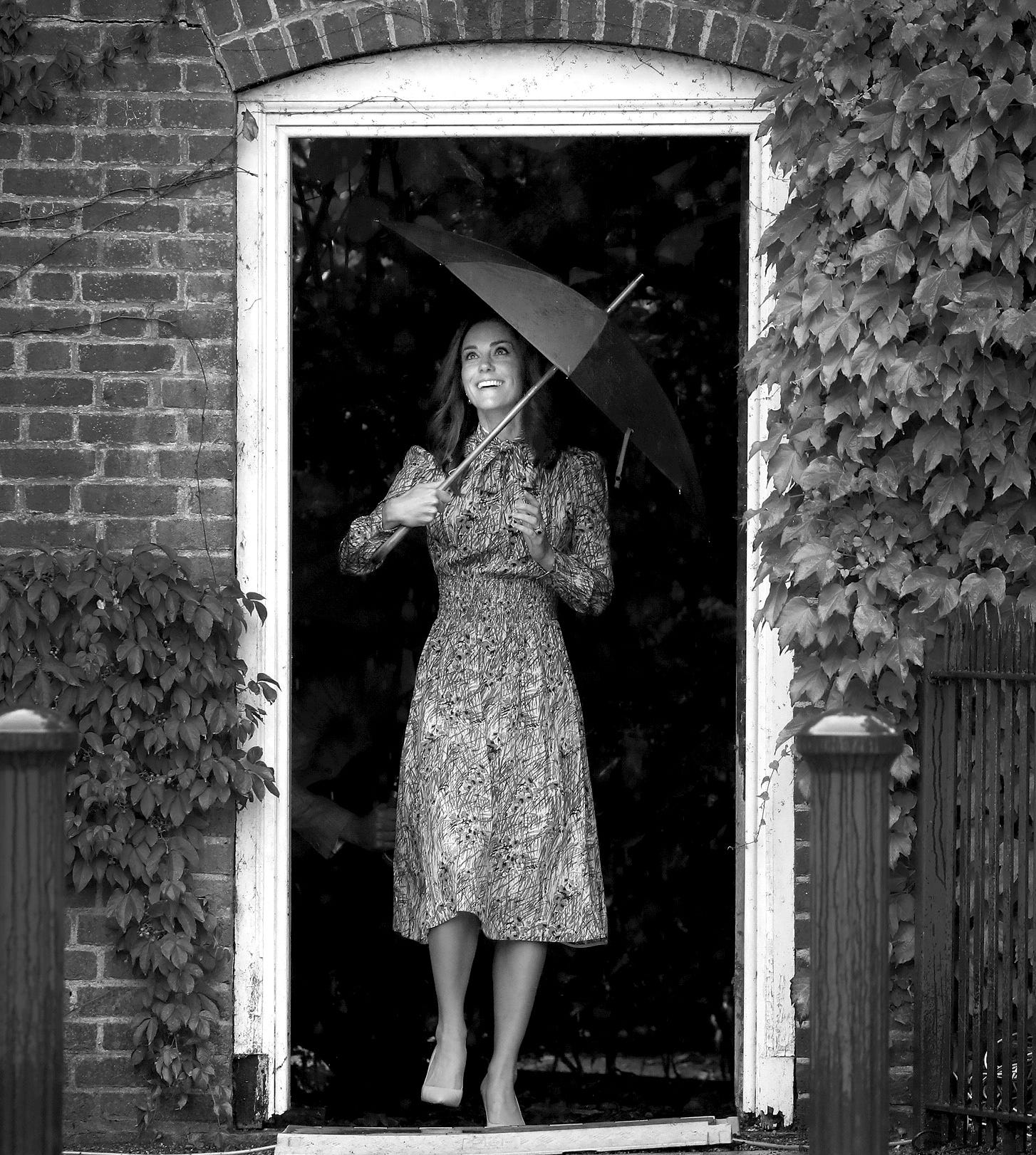 Kate Middleton hält einen Regenschirm, als sie den versunkenen Garten im Kensington Palace besucht