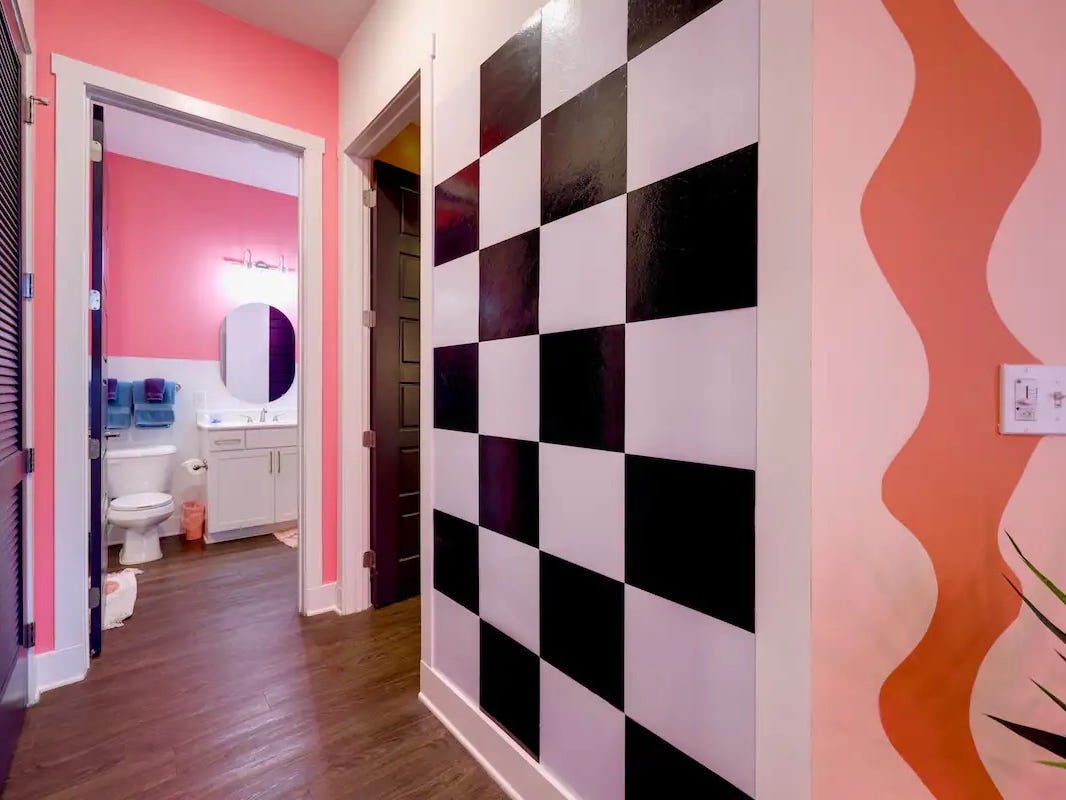 Die Wände der Wohnung sind mit einem Schachbrettmuster und einem orangefarbenen, verschnörkelten Liniengemälde verziert