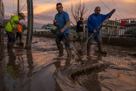 Anwohner arbeiten daran, nassen Schlamm zurückzudrängen, der am 11. Januar 2023 in der kleinen Stadt Piru ohne eigene Rechtspersönlichkeit, östlich von Fillmore, Kalifornien, Autos eingeschlossen und in einige Häuser eingedrungen ist.