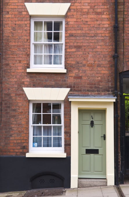Kleines Stadthaus mit grüner Eingangstür und cremefarbenem Rahmen und weißen Schiebefenstern in Ludlow, Shropshire