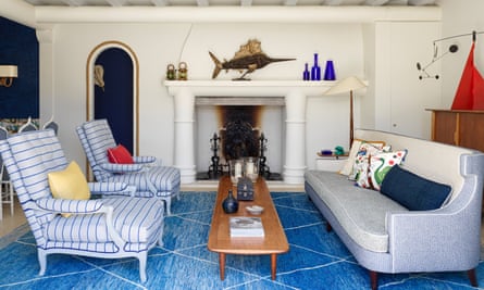 Das Wohnzimmer im maritimen Stil mit blauem Teppich, blauem Sofa und zwei blau-weißen Stühlen.