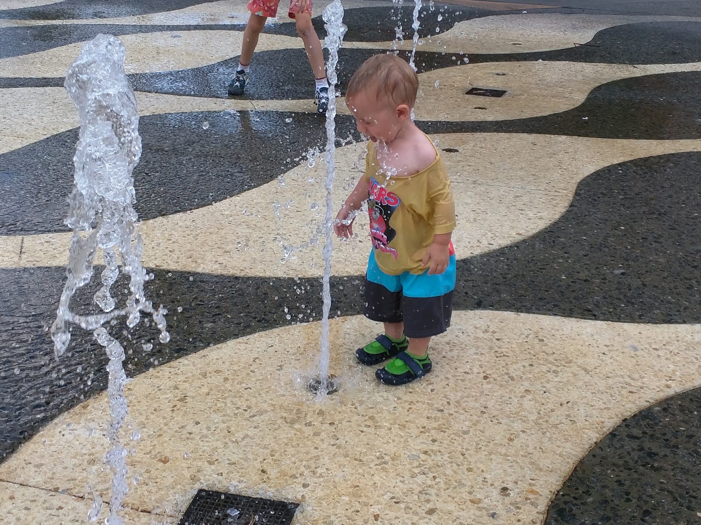 Kleinkind spielt im Wasser an einem Splash Pad im Universal Studios Citywalk Bereich