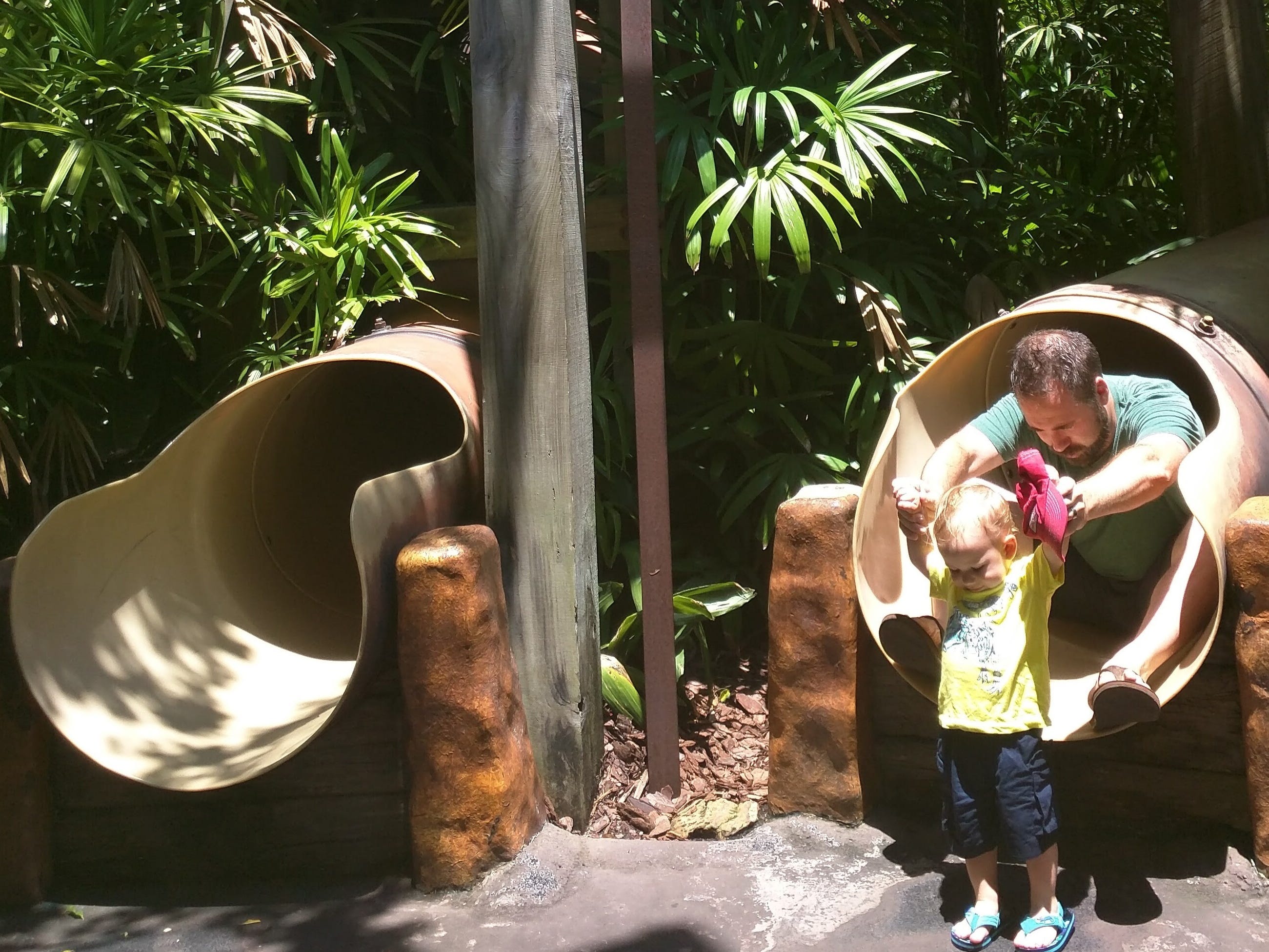 Kleinkind und Eltern rutschen auf dem Jurassic Park Spielplatz auf den Abenteuerinseln bei Universal herunter