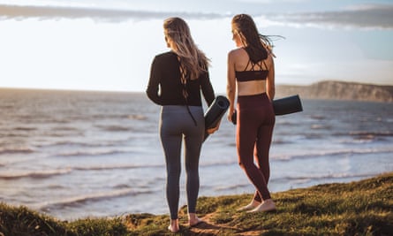 Frauen am Strand mit Yogamatten