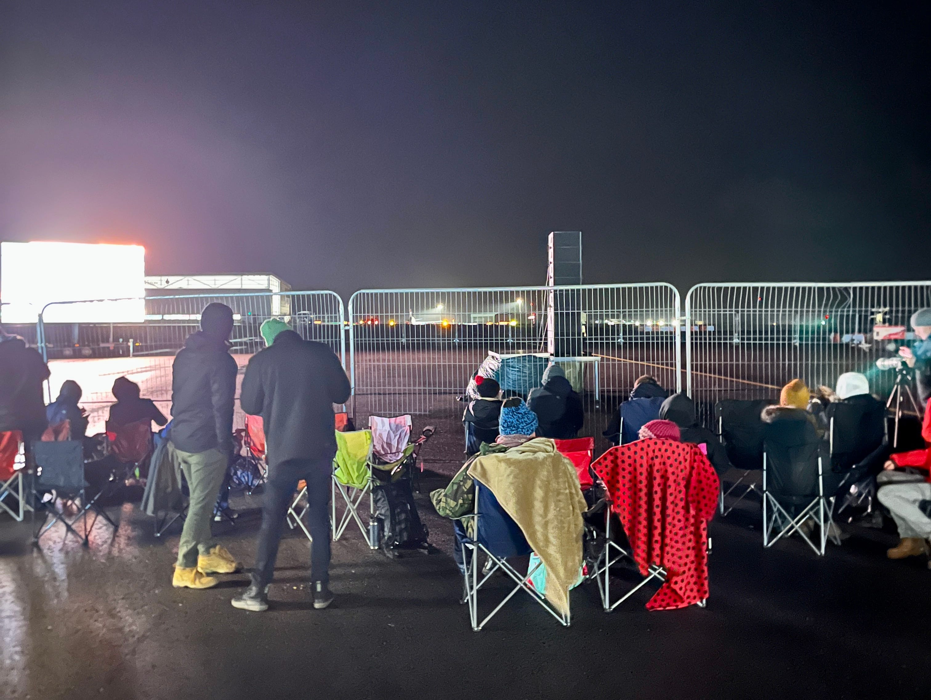 Menschen stellen Stühle am Zaun am Spaceport Cornwall auf.