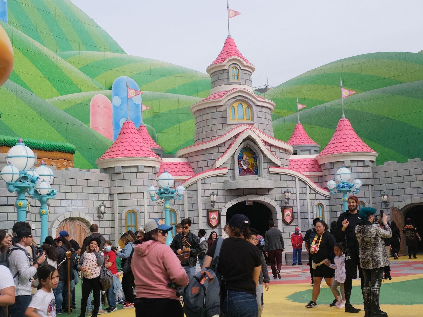 Gäste gehen am Schloss von Prinzessin Peach während einer Vorschau auf Super Nintendo World in den Universal Studios in Los Angeles, Kalifornien, am 13. Januar 2023 vorbei.