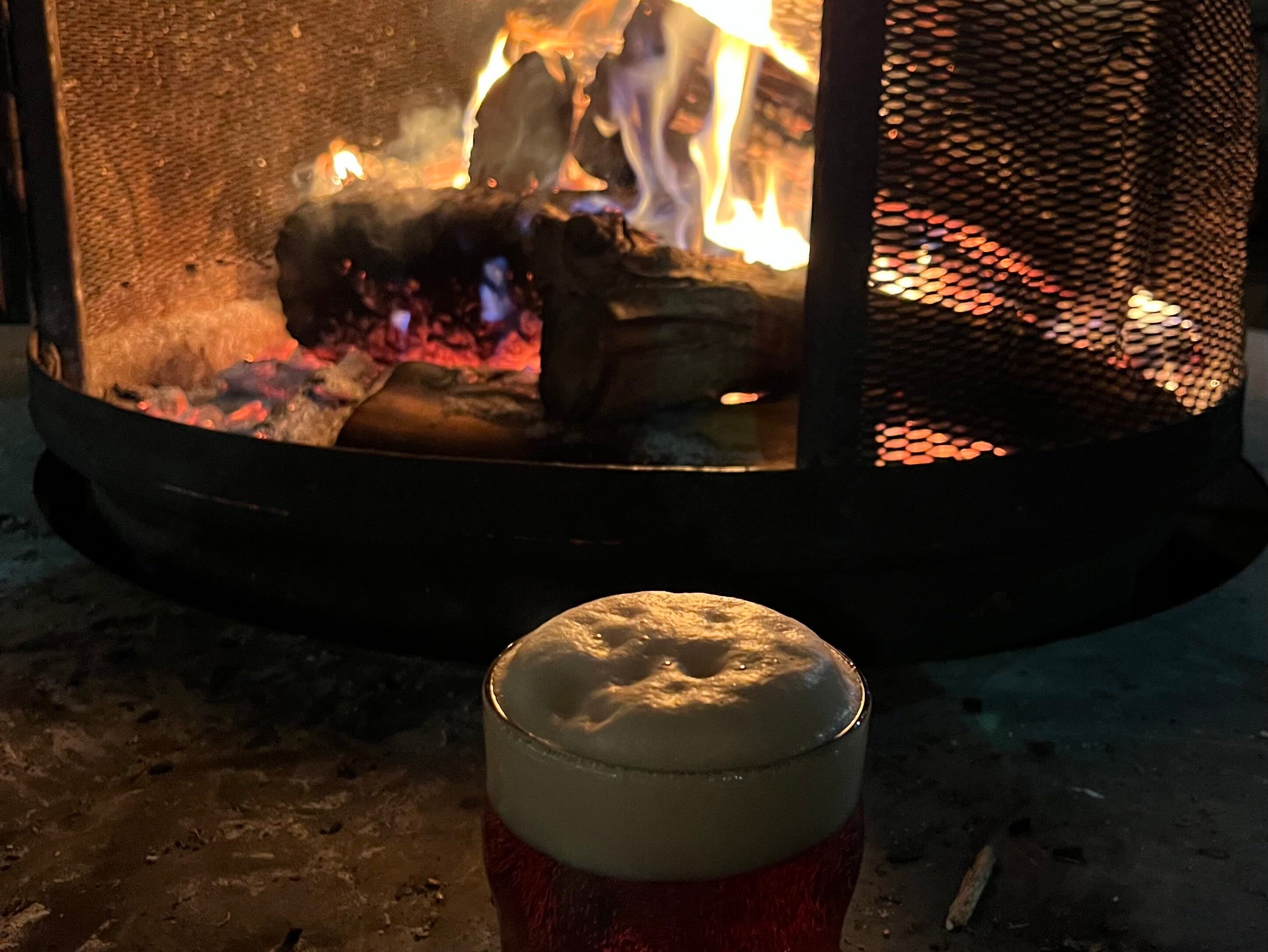 Ein Bier vor einem Feuer.