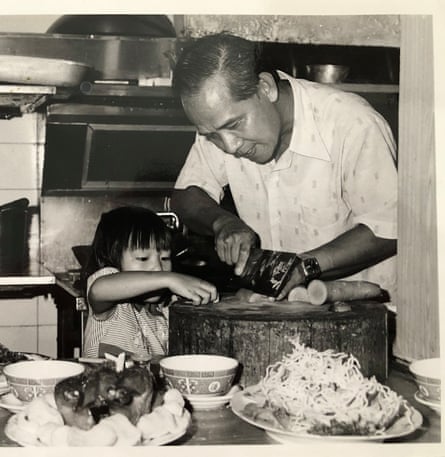 Ein Schwarz-Weiß-Foto eines kleinen Kindes mit ihrem Vater in einer Restaurantküche. 