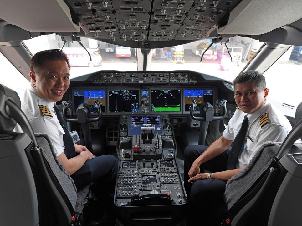 Kapitän Ian Cheng (L) und Kapitän Alan Chan Wai Fook (R) posieren für ein Foto im Cockpit der B787-10 von Singapore Airlines (SIA) nach ihrer Ankunft aus der Boeing-Produktionsstätte in North Charleston, South Carolina, am Singapore Changi Airport 28. März 2018.