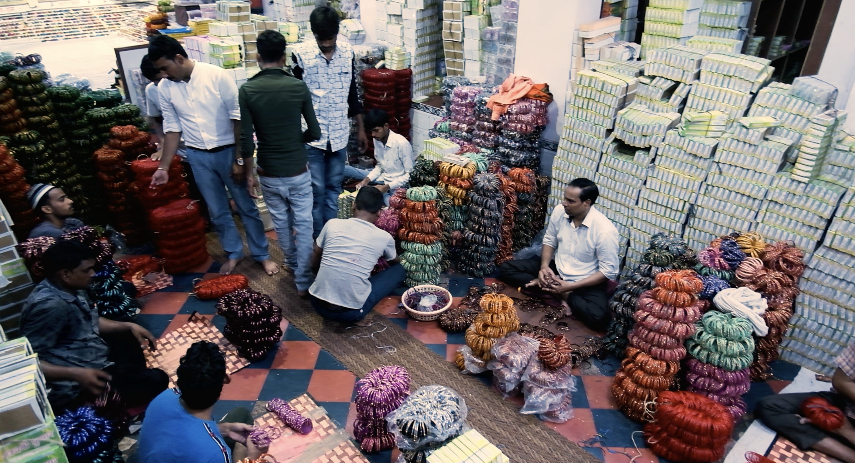 Männer kaufen und verkaufen Armreifen in einem Geschäft in Firozabad