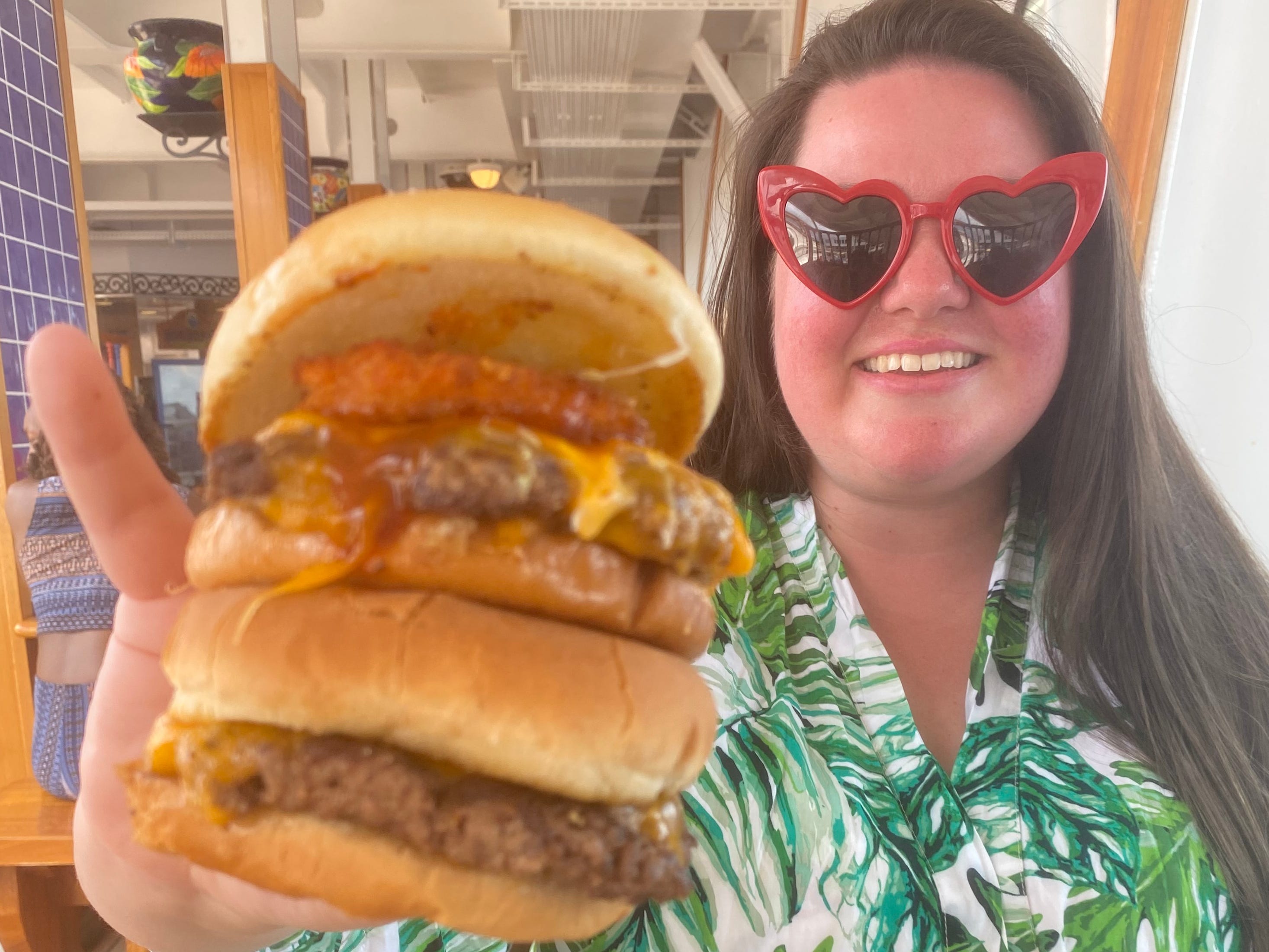 Guy's Burger Joint Megan duBois hält Burger lächelnd hoch