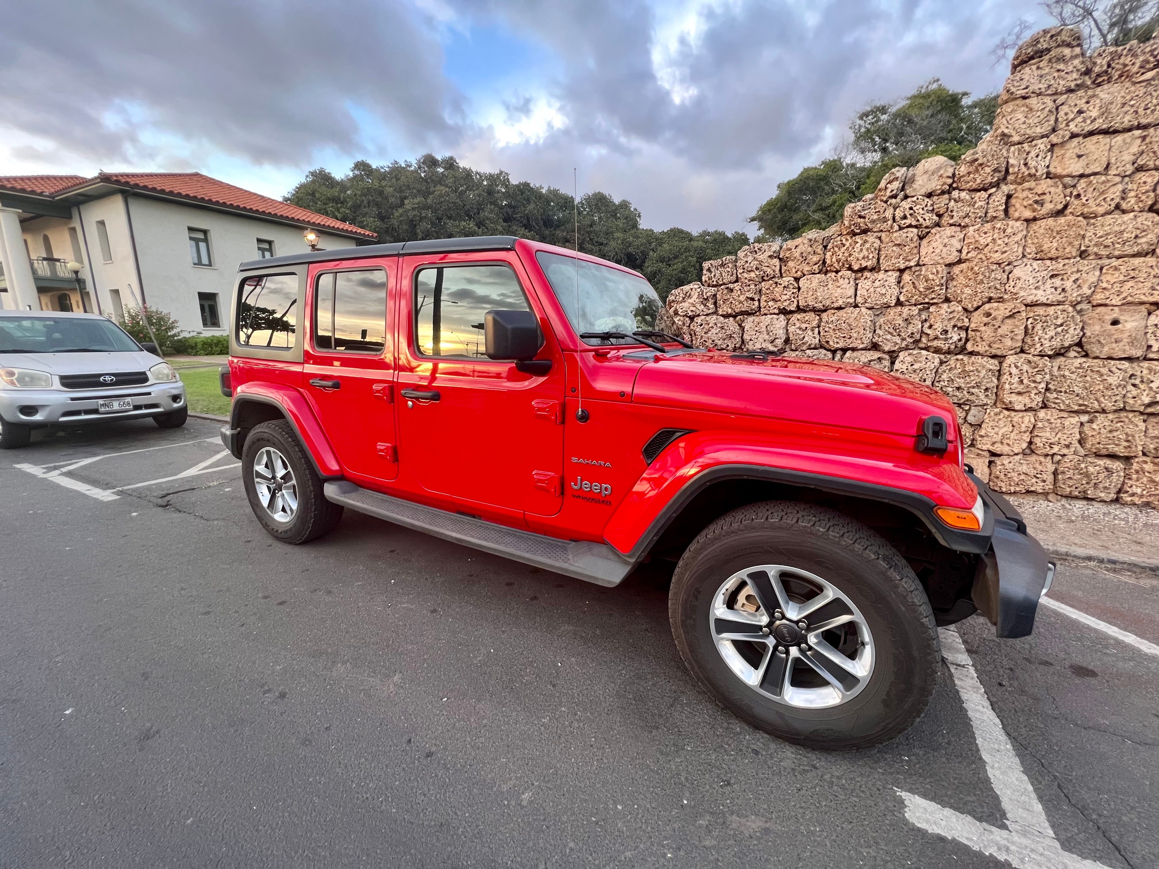 roter Jeep am Straßenrand in Hawaii geparkt