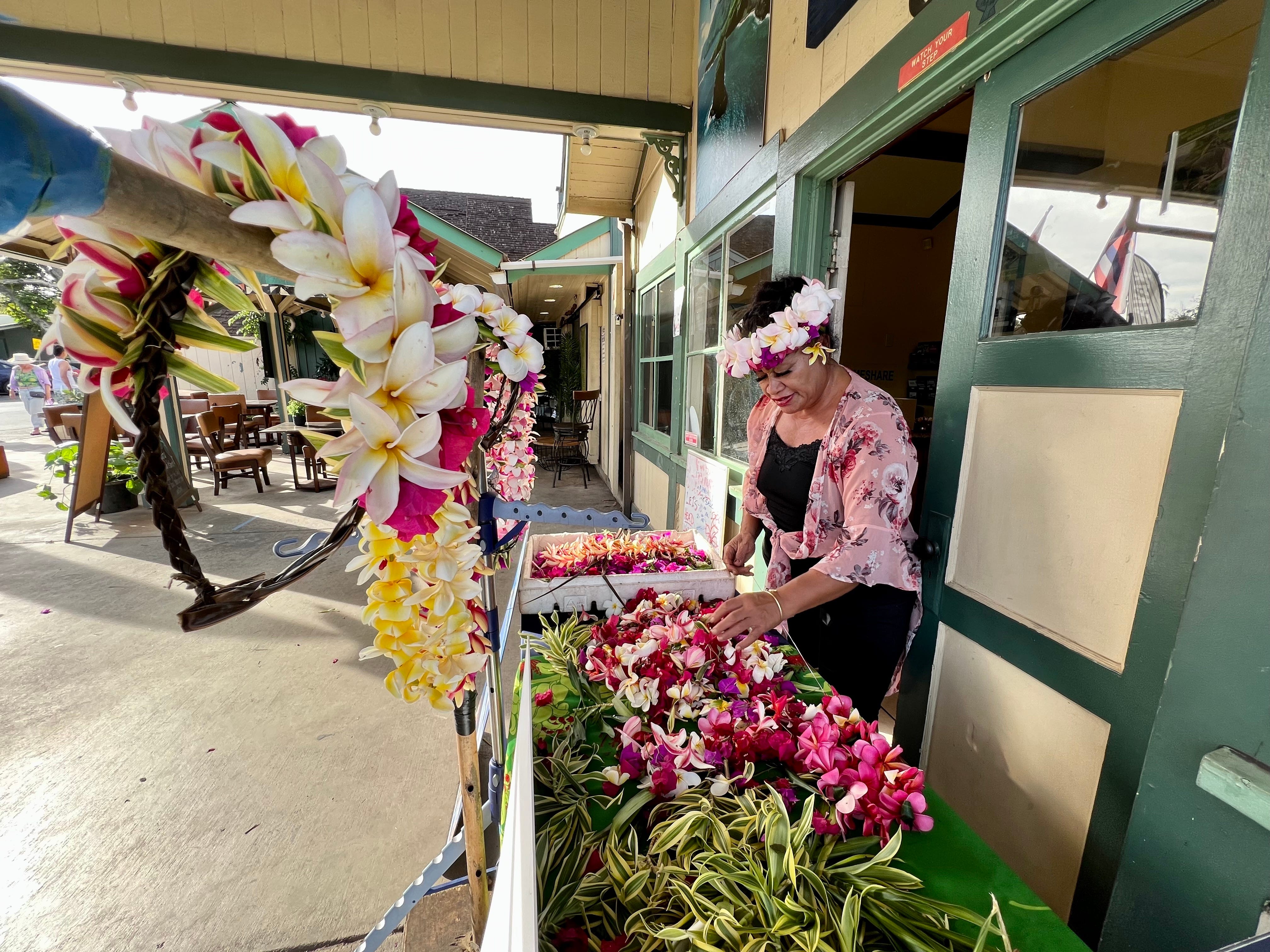 lokaler lei-Hersteller in hawaii, frau, die hinter dem stand steht, der leis verkauft