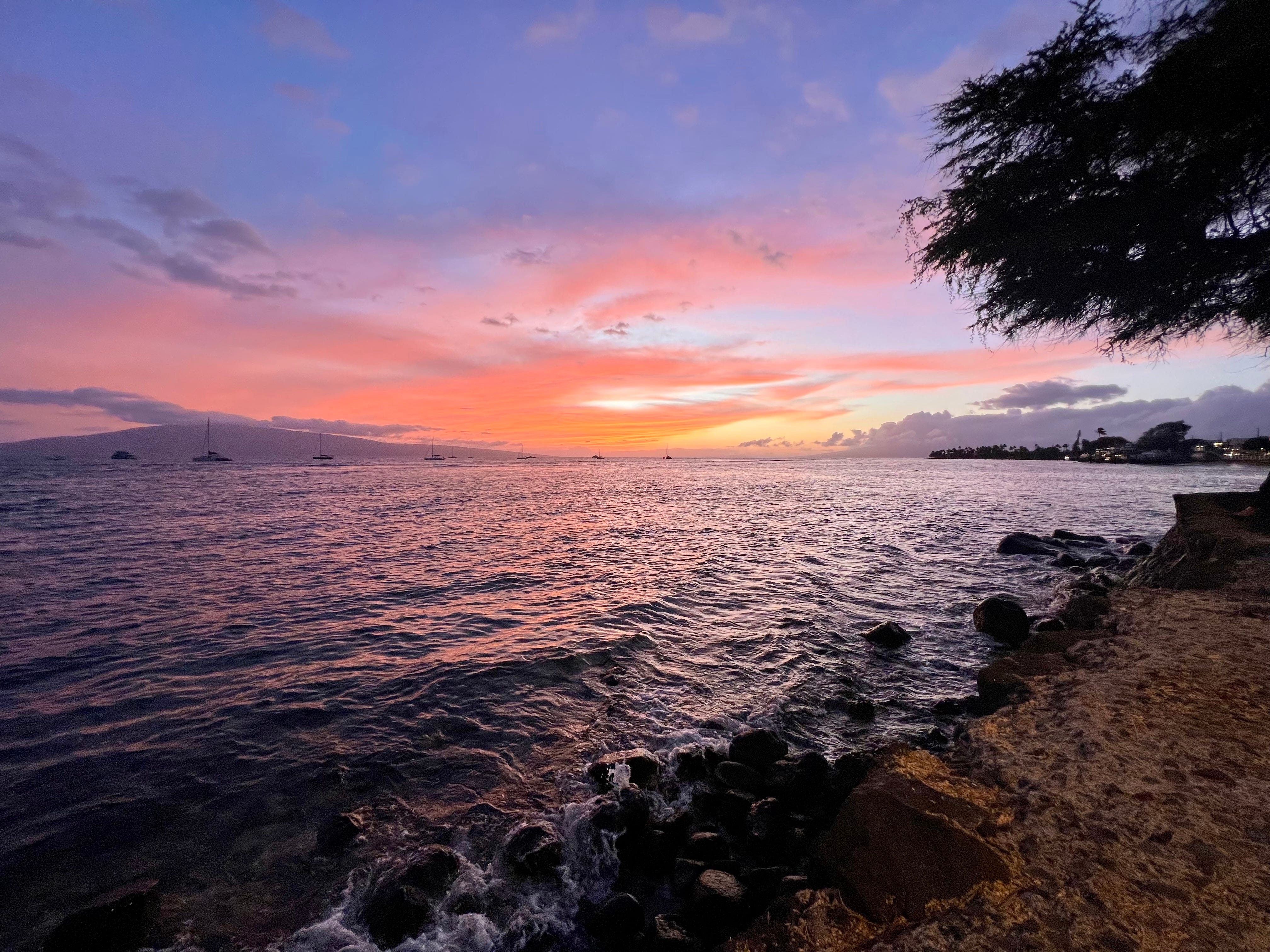 Sonnenuntergang in Hawaii am Strand, Orange-, Gelb- und Blautöne in der Ferne