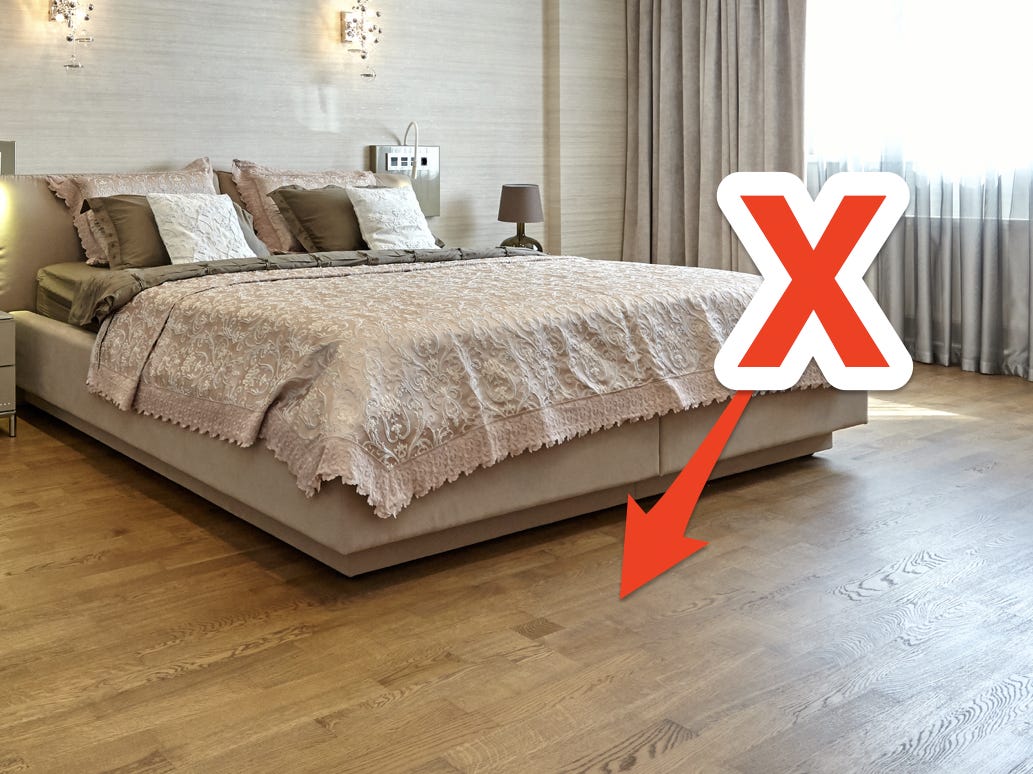 Bett mit nackten Holzböden und rotem X und Pfeil, der auf den Boden zeigt
