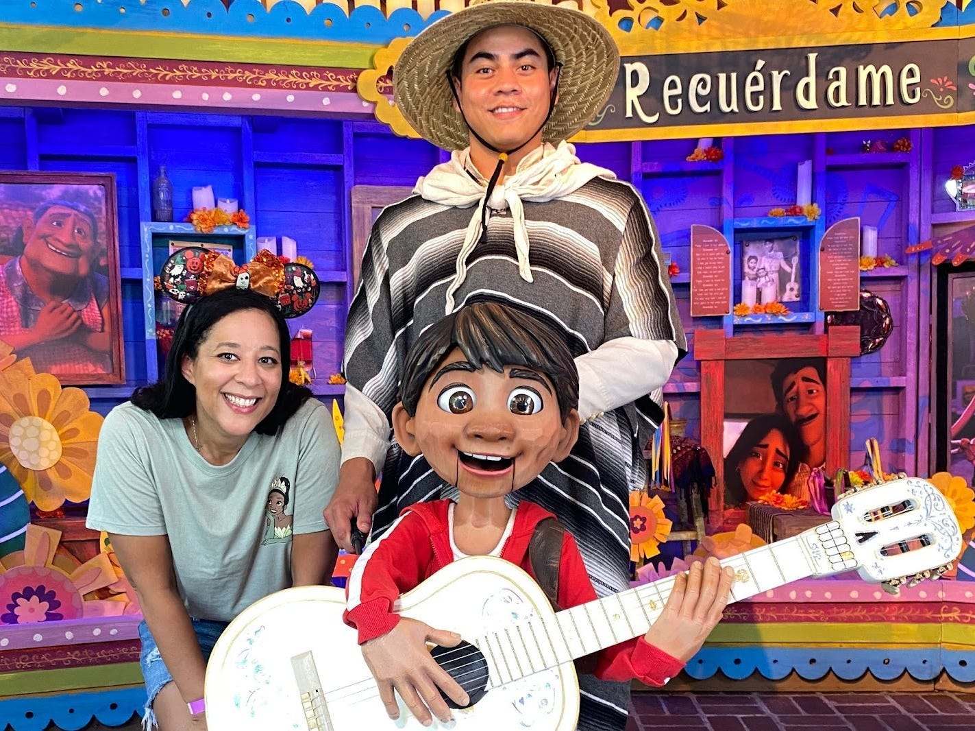 Tiffany A. Telles steht neben der Statue von Miguel aus dem Disney-Film „Coco“ und Mitarbeiterin von Disneyland