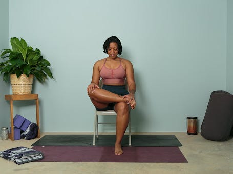 Eine Person in Trainingskleidung, die die Stuhltauben-Yoga-Pose durchführt.