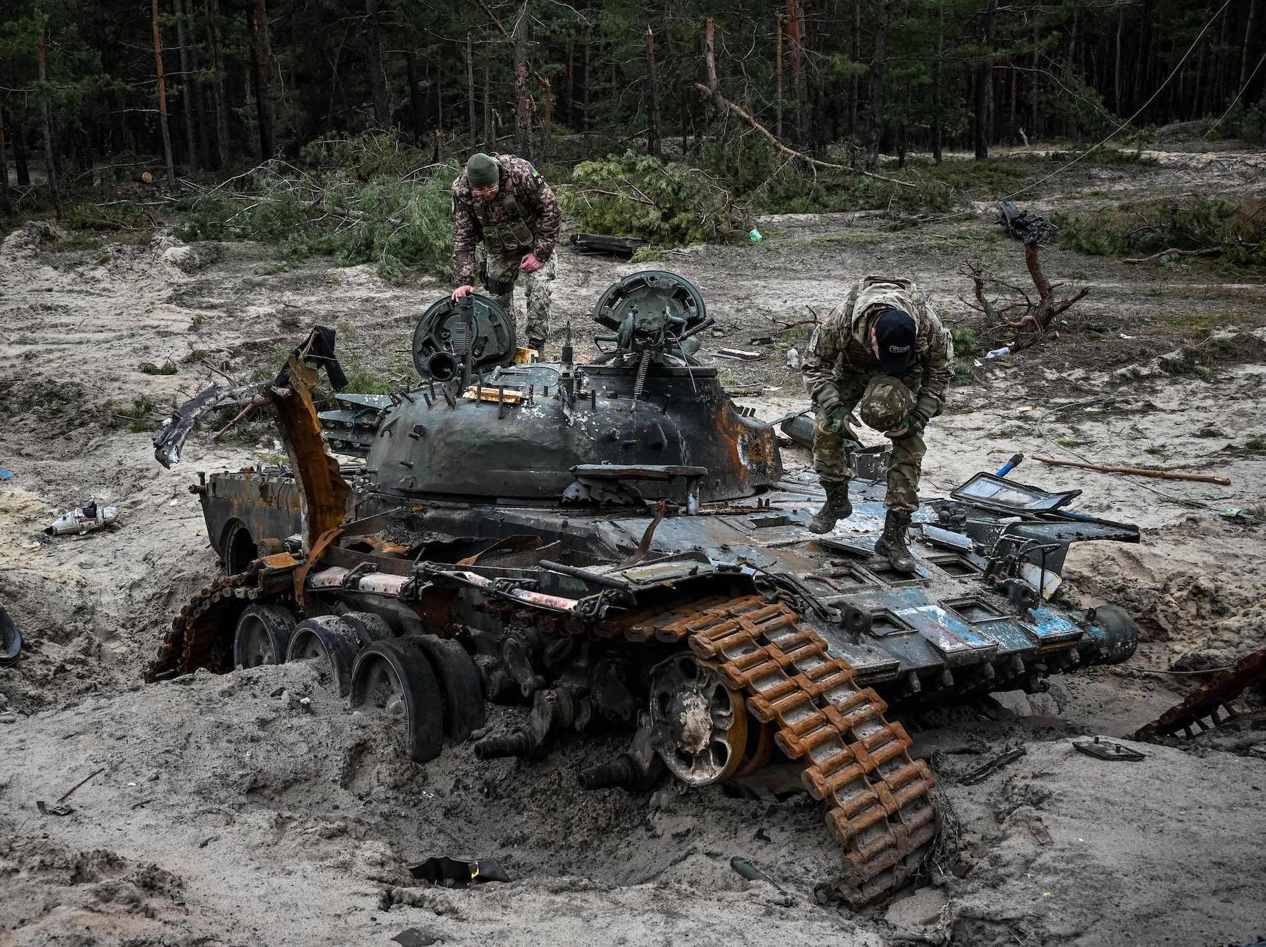 Ukrainische Truppen inspizieren einen zerstörten russischen Panzer