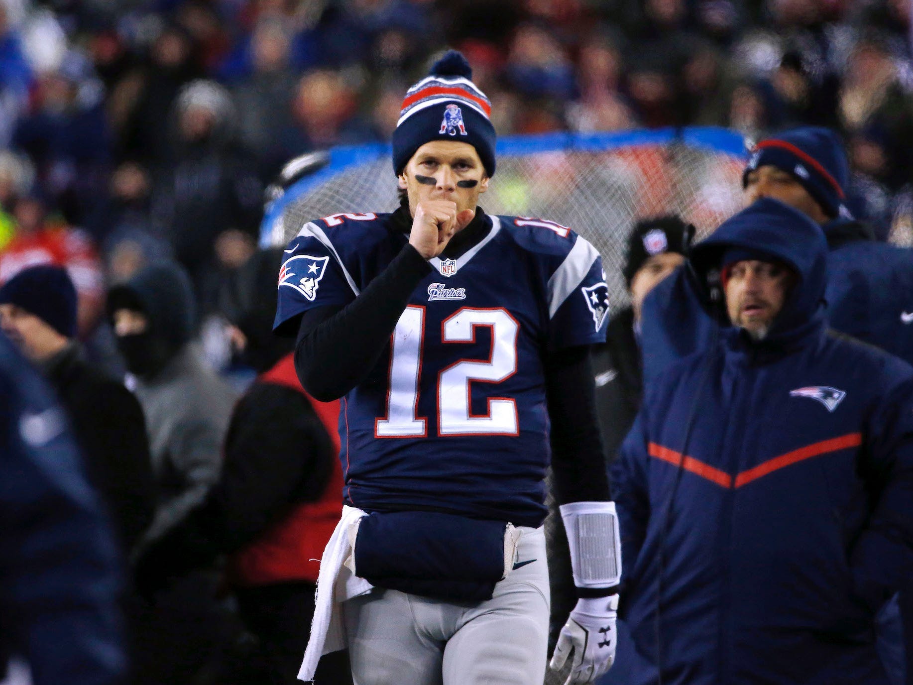 Tom Brady läuft an der Seitenlinie und bläst ihm 2015 in die Hand.