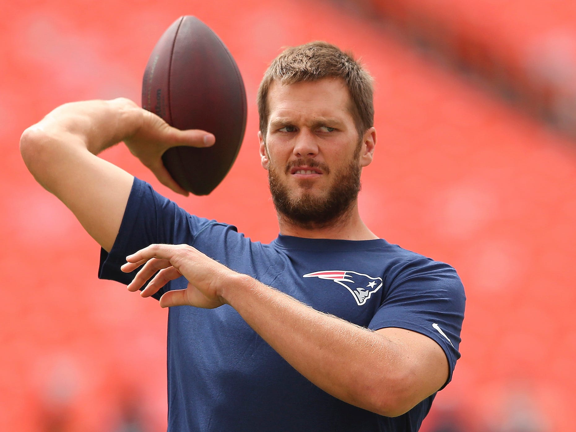 Tom Brady blinzelt, während er 2014 einen Fußball wirft.