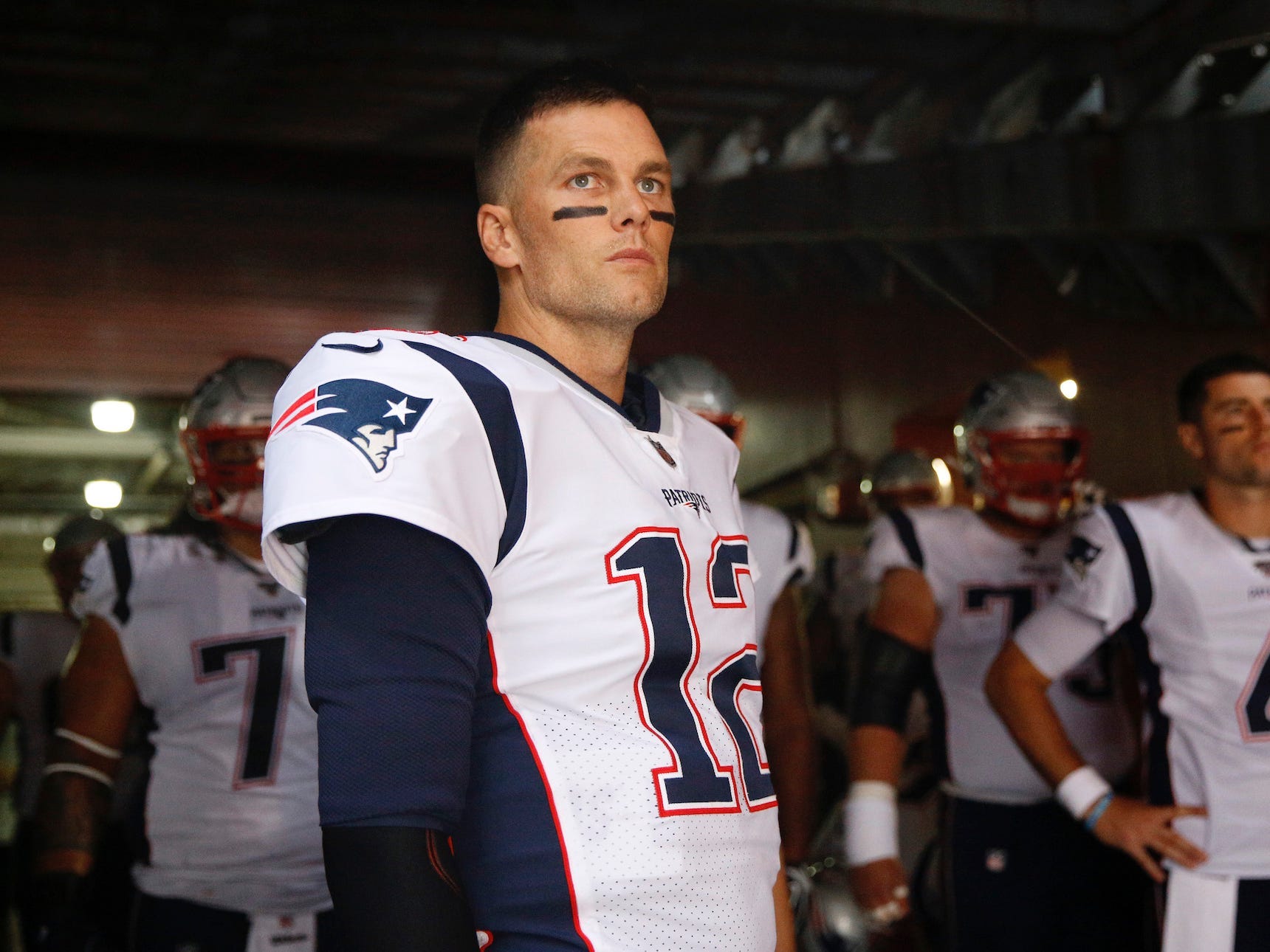Tom Brady steht vor einem Spiel im Jahr 2019 mit Patriots-Spielern im Tunnel.