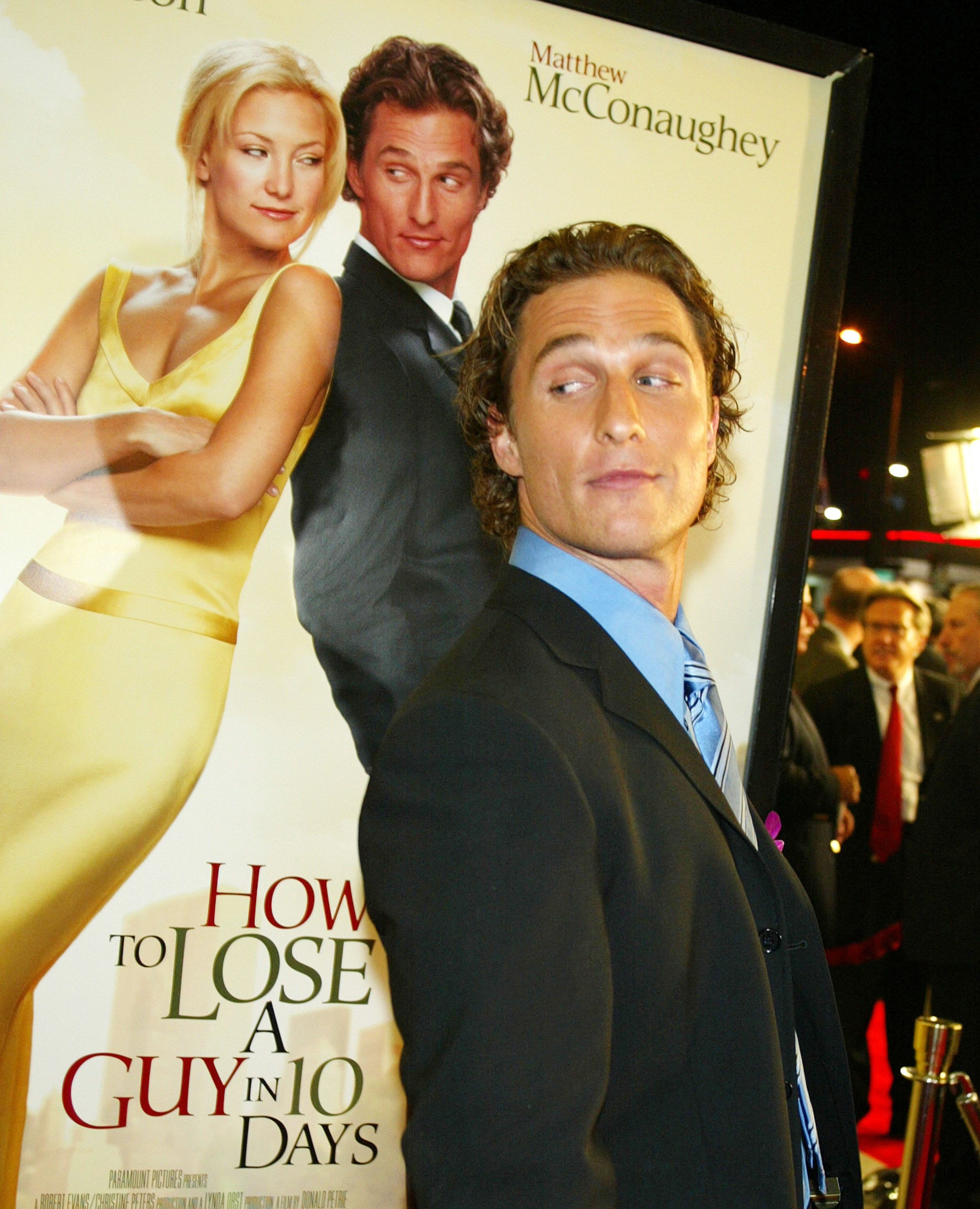 Matthew McConaughey steht neben einem Poster von How to Lose a Guy in 10 Days