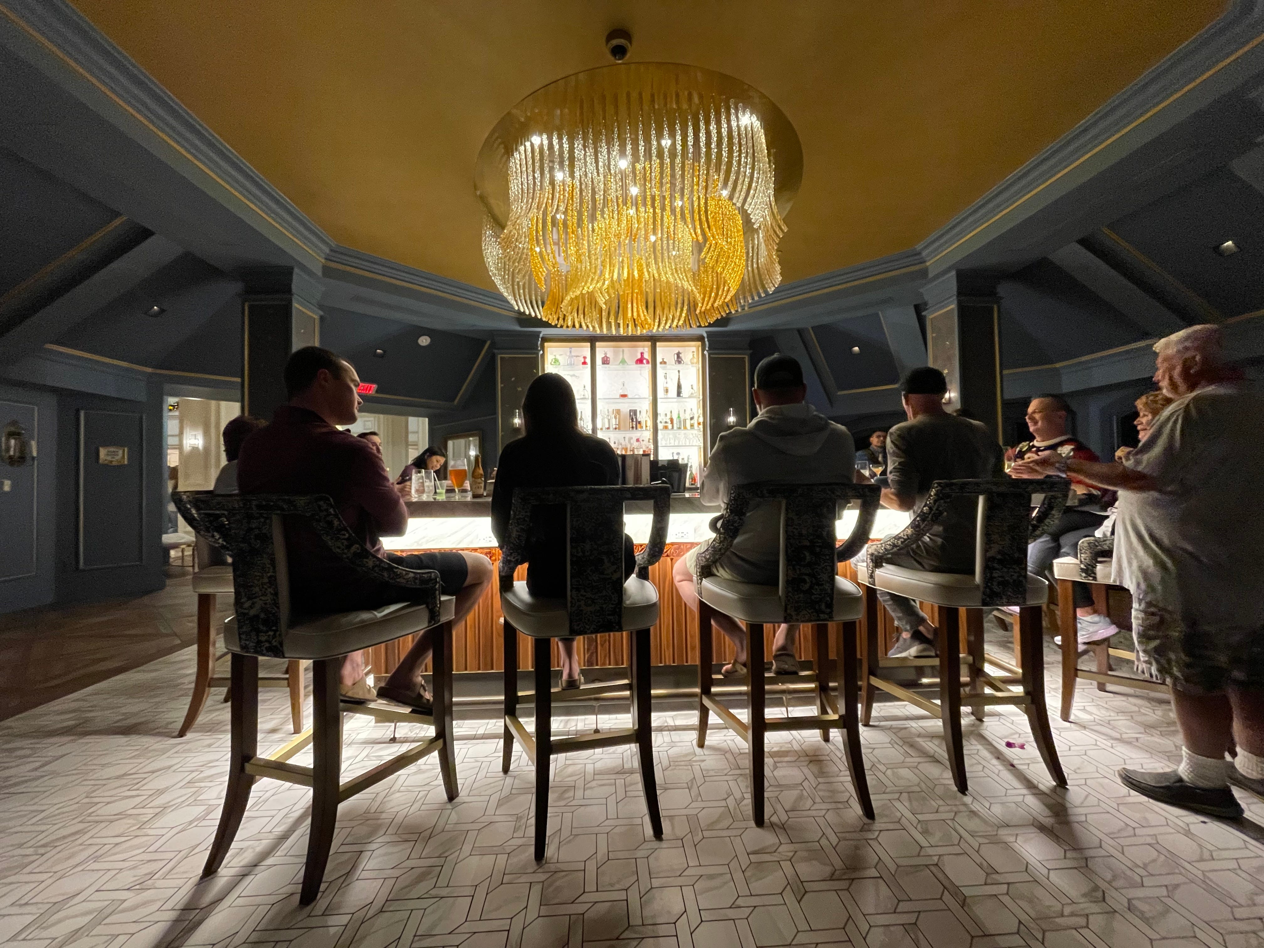 Menschen sitzen an der Bar in der Enchanted Rose Lounge im Grand Florida Resort von Disney