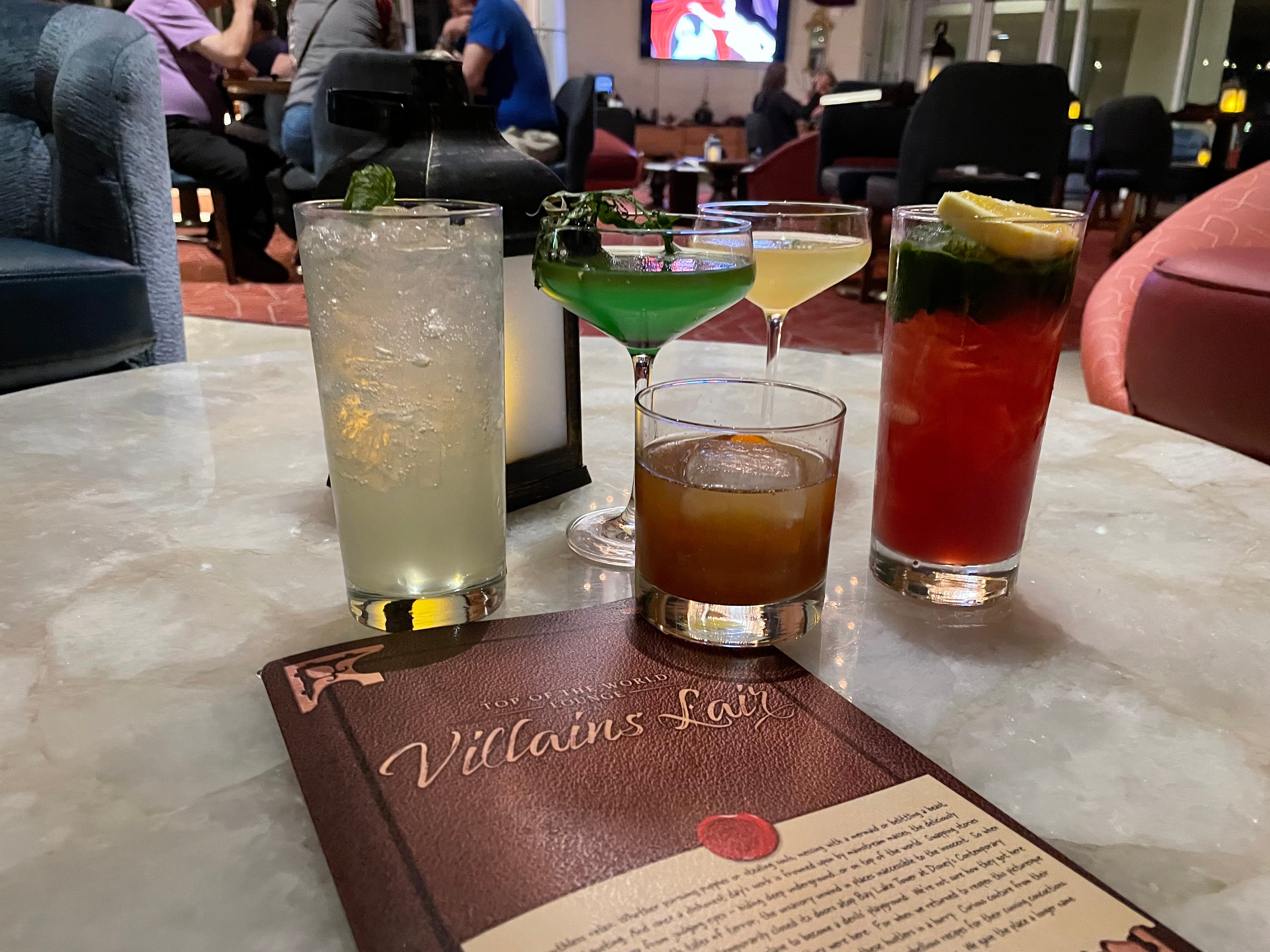 Runde Cocktails auf einem Tisch neben einem Menü aus Villain's Lounge in Disneys modernem Resort