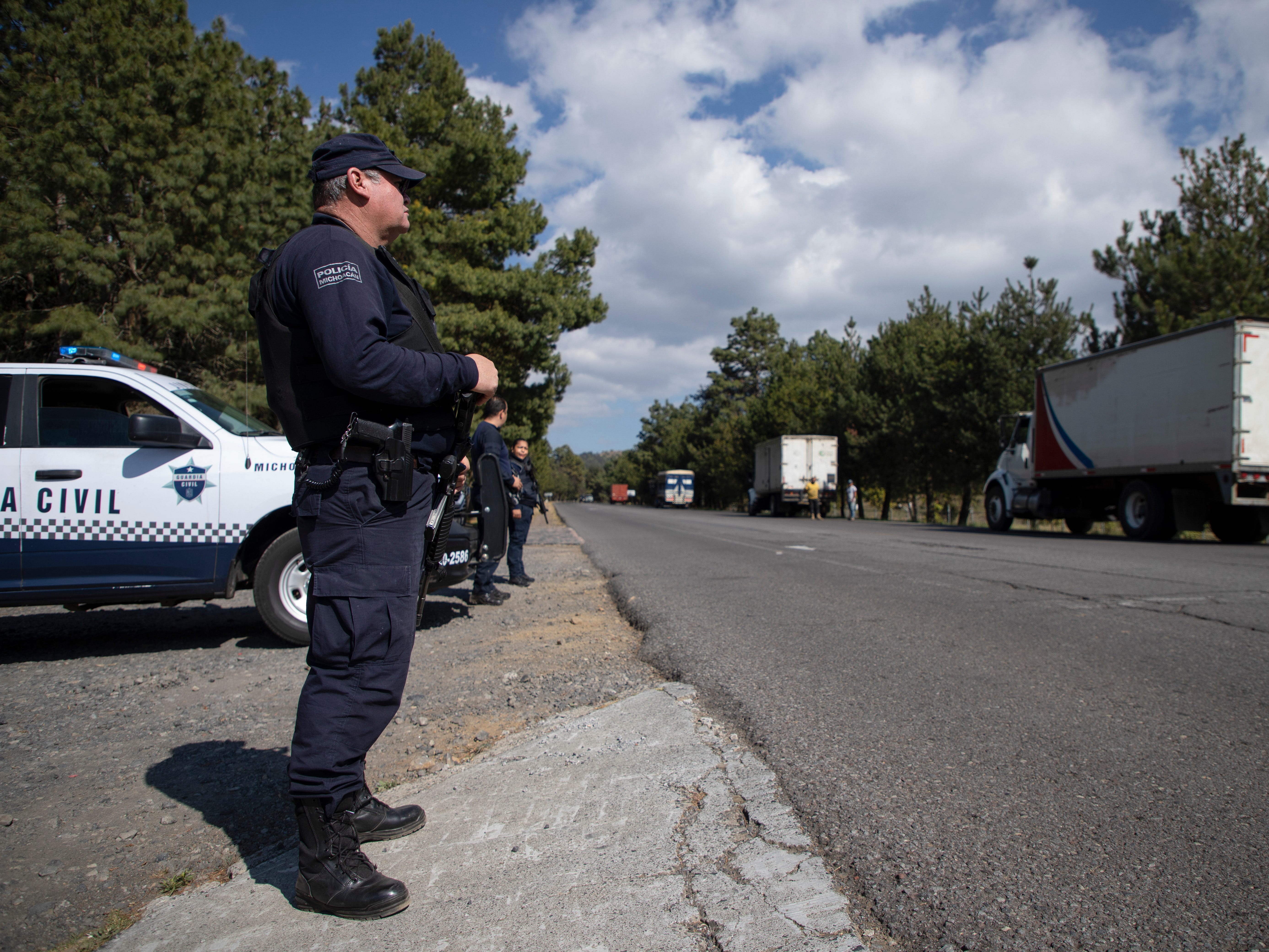 Polizei bewacht mit Avocados beladene Lastwagen auf dem Weg in die Stadt Uruapan in Santa Ana Zirosto, Bundesstaat Michoacan, Mexiko, Donnerstag, 26. Januar 2023.
