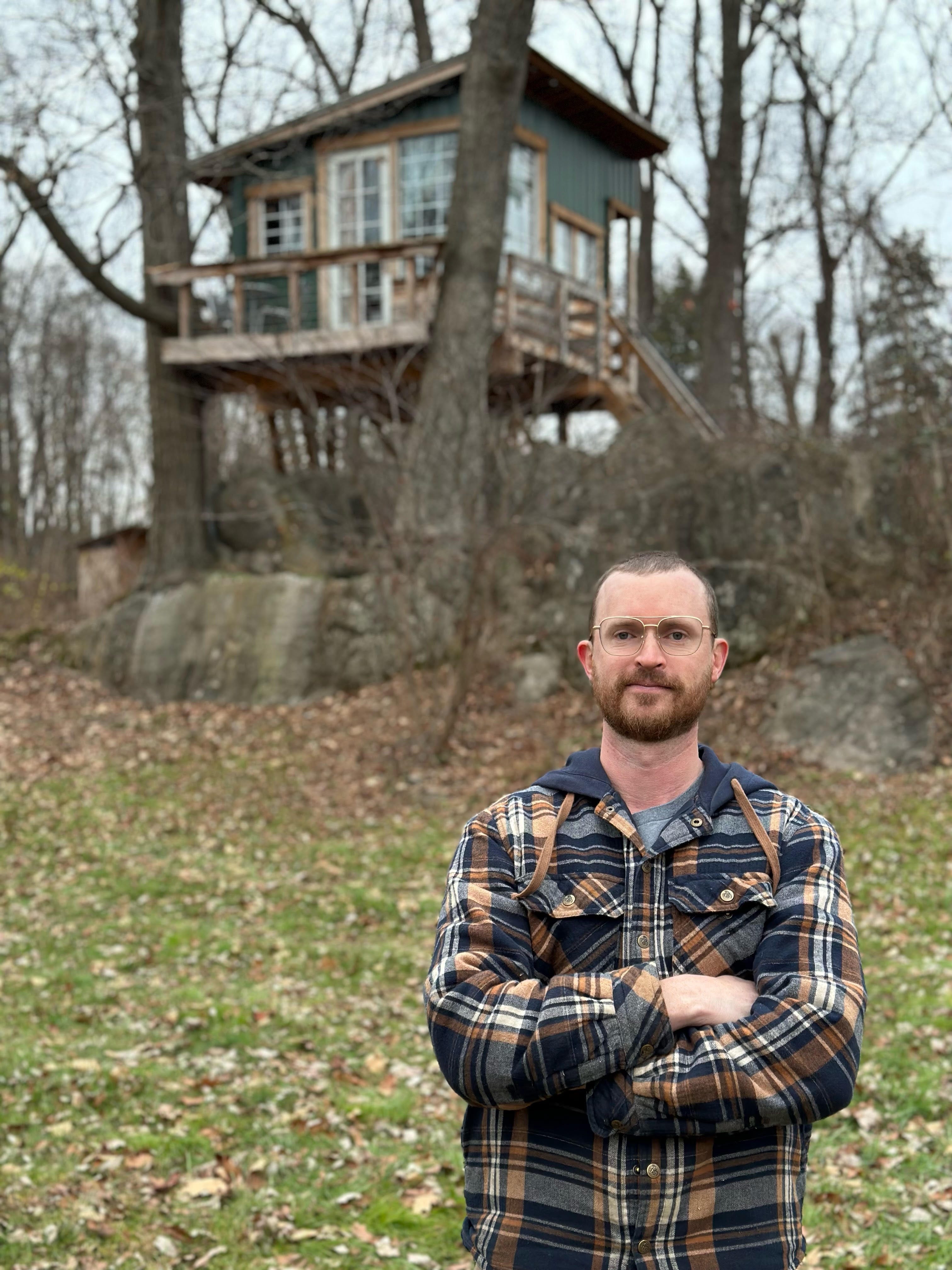 Will Sutherland vor seinem Baumhaus Airbnb