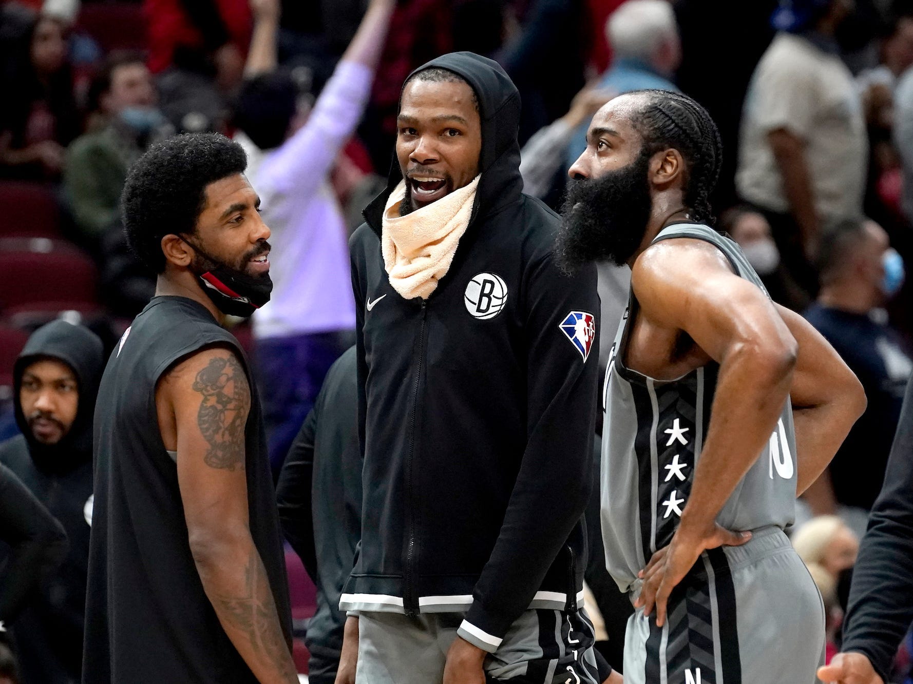 Kyrie Irving, Kevin Durant und James Harden stehen im Kreis, lächeln und reden während eines Spiels der Nets im Jahr 2021.