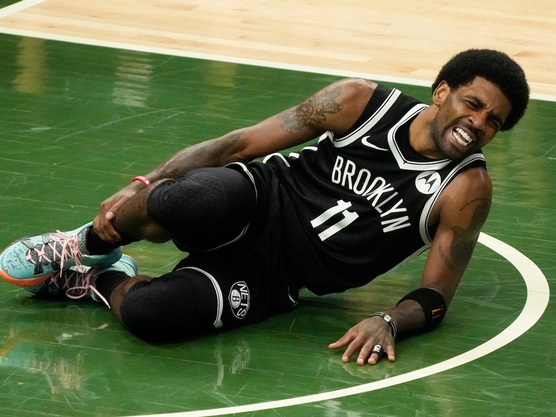 Kyrie Irving hält seinen Knöchel, während er während eines Spiels vor Schmerzen auf dem Boden liegt.