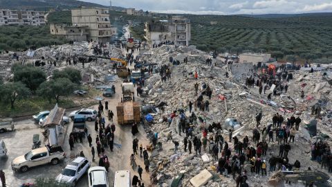 Zivilschutzmitarbeiter und Anwohner durchsuchen am Montag die Trümmer eingestürzter Gebäude in der Stadt Harem nahe der türkischen Grenze in der Provinz Idlib in Syrien.