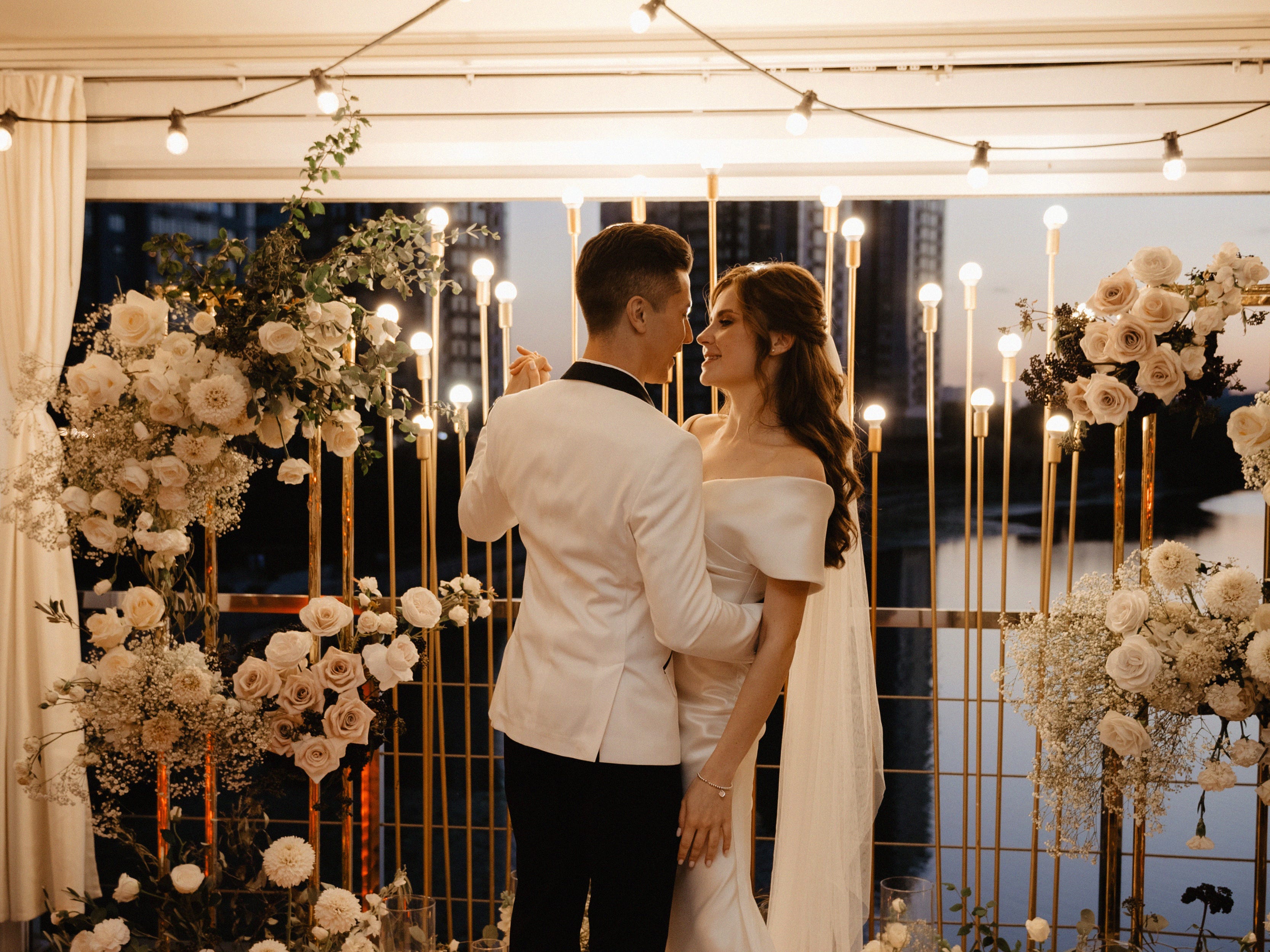 Braut und Bräutigam, umgeben von Kerzen, tanzen auf einer Terrasse mit Blick auf den Fluss Dnipro.