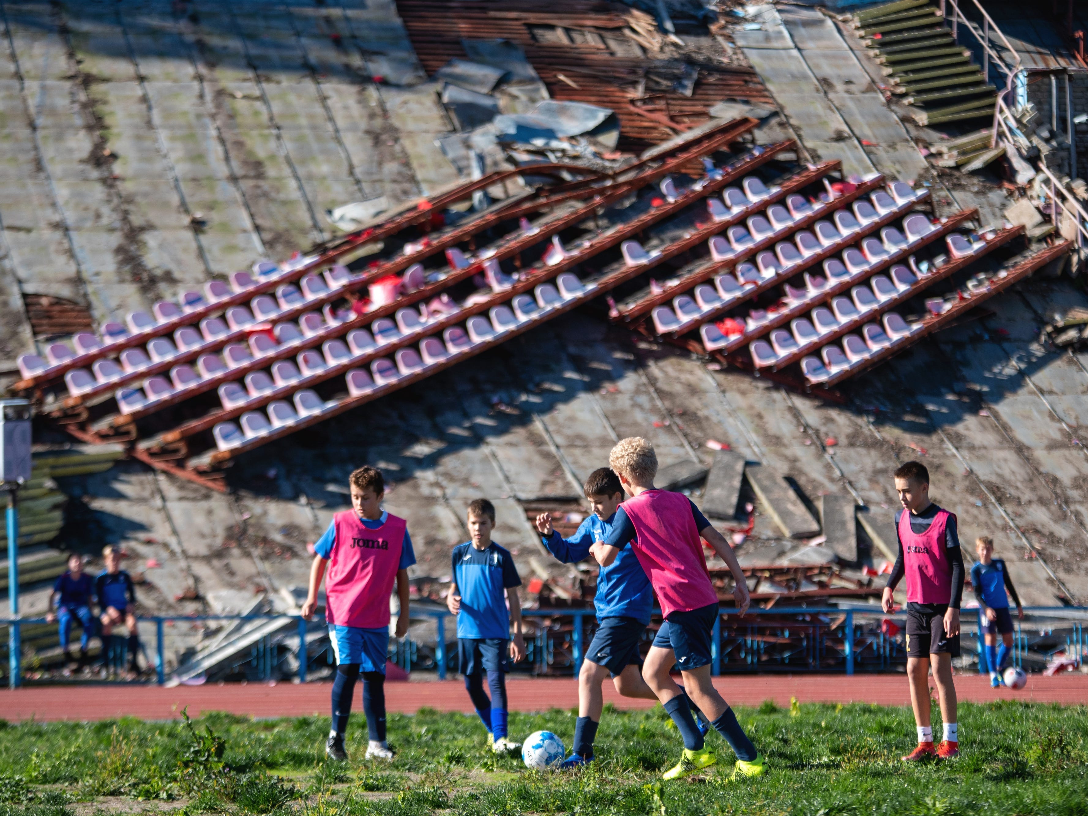 Eine Kinderfußballmannschaft trainiert in einem zerstörten Stadion in Tschernihiw.