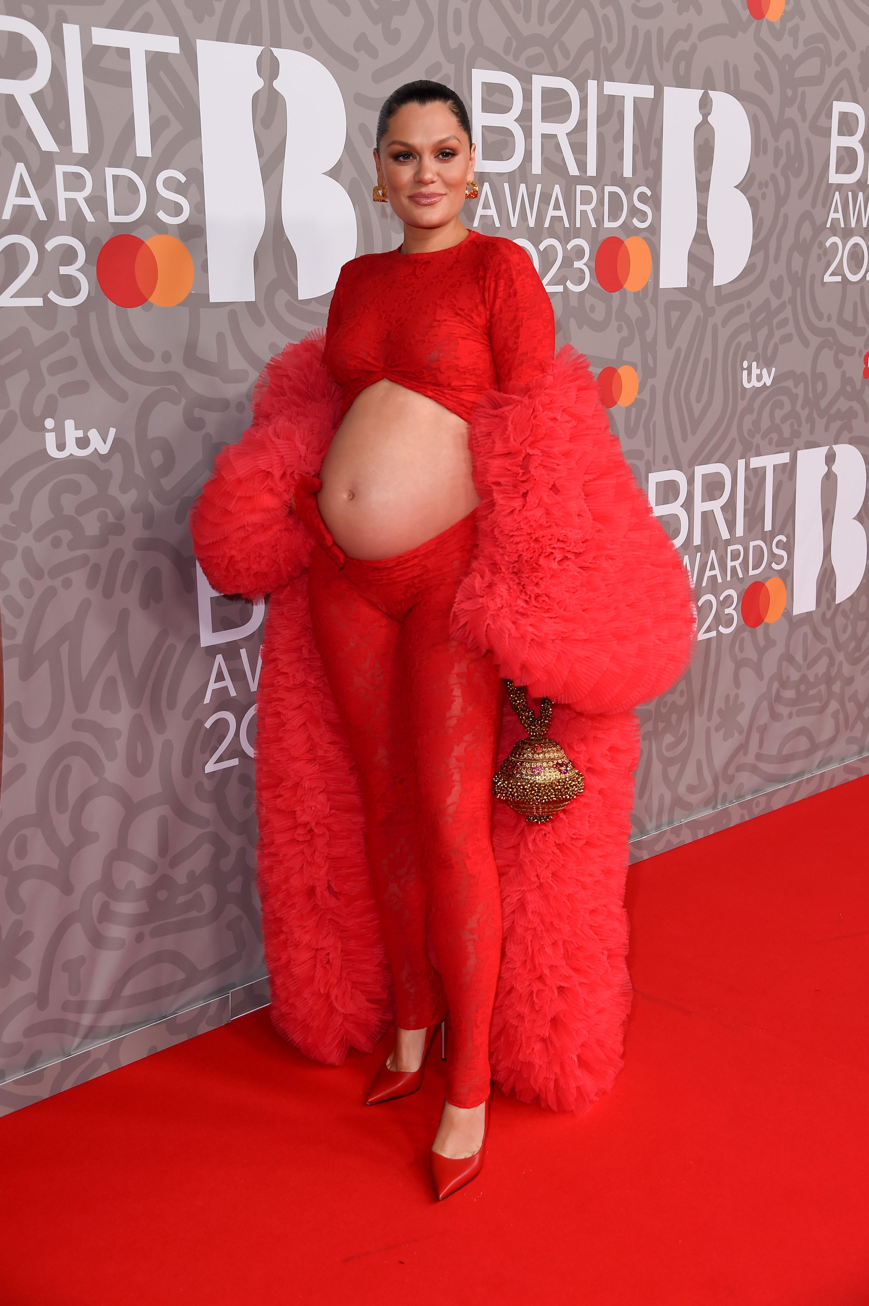 Jessie J in einem roten Spitzen-Catsuit auf dem roten Teppich bei den Brit Awards 2023
