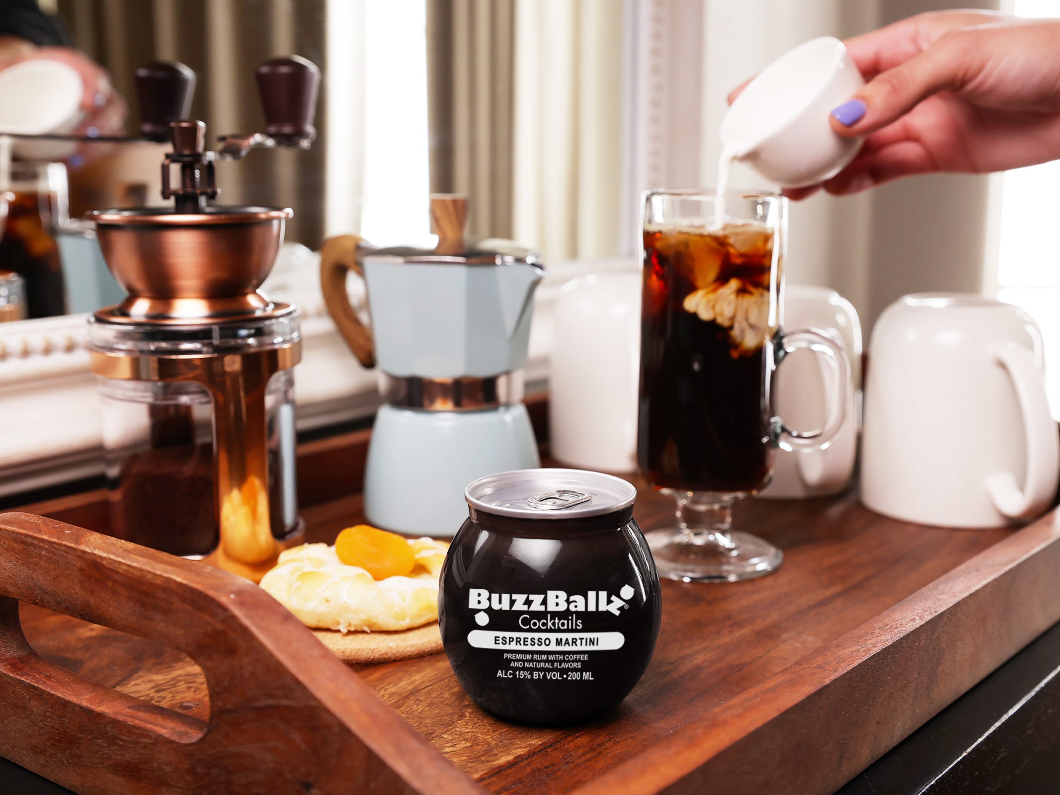 Ein Holztablett mit einem BuzzBallz Espresso Martini und Kaffeezubehör