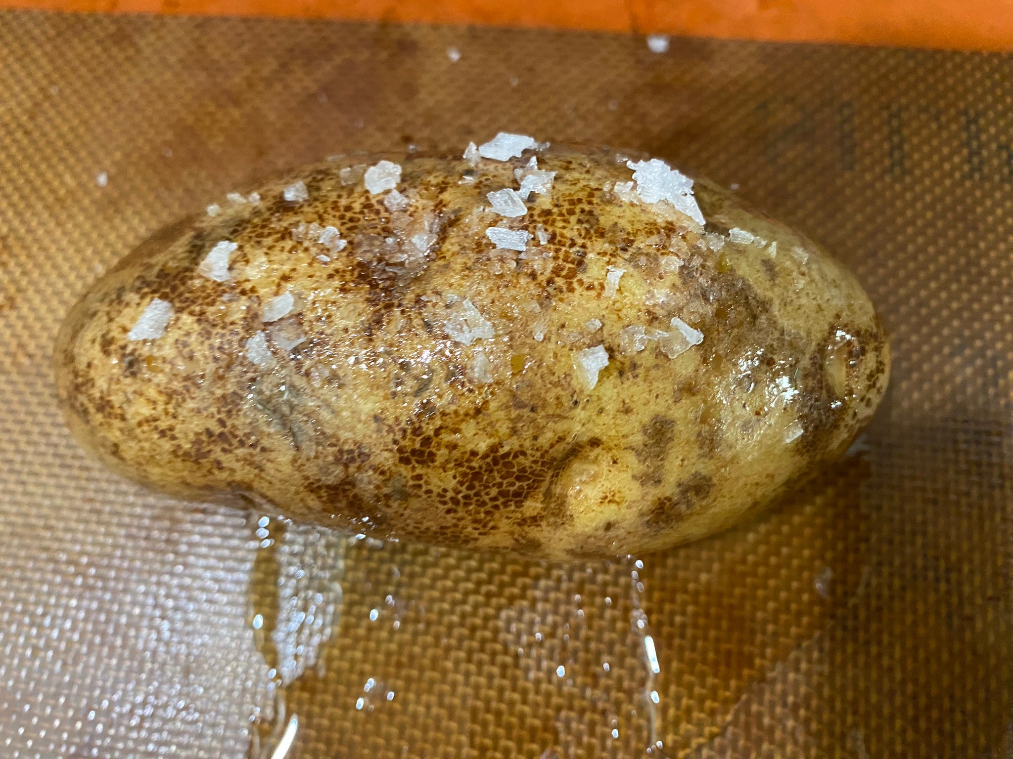 Kartoffel bedeckt mit Salz und Öl auf einem Backblech