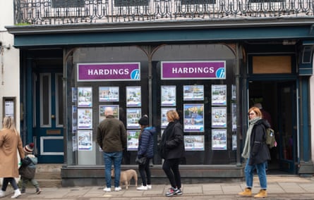 Menschen sehen sich Immobilien zum Verkauf im Schaufenster eines Immobilienmaklers in Windsor, Berkshire, an.