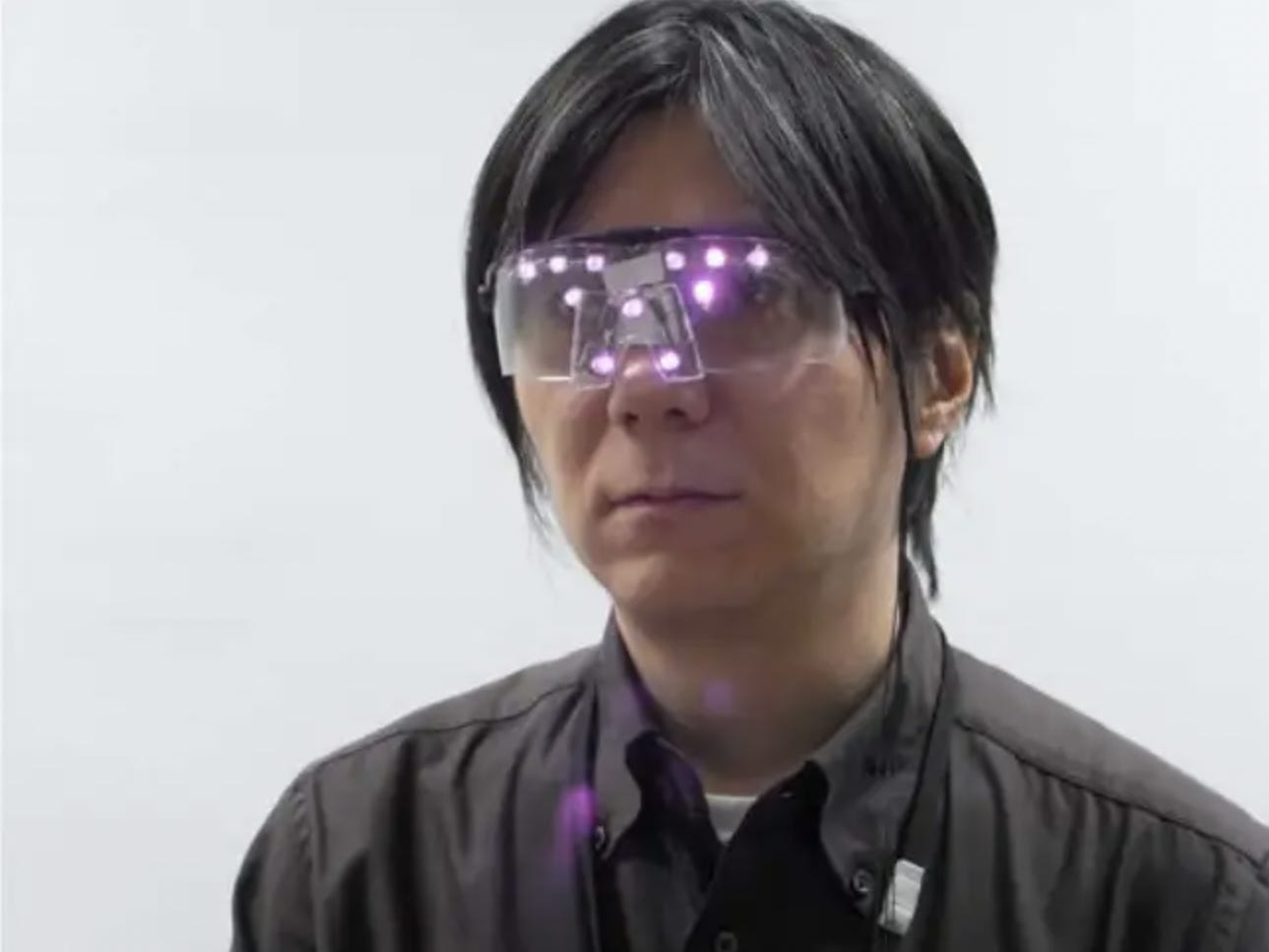 Ein Mann trägt eine Brille mit violetten LED-Leuchten
