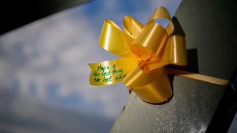   Gelbe Bänder und herzförmige Papiernotizen, die mit Botschaften der Hoffnung und des guten Willens geschmückt sind, sind an der Fußgängerbrücke im Dorf St. Michael's on Wyre befestigt.